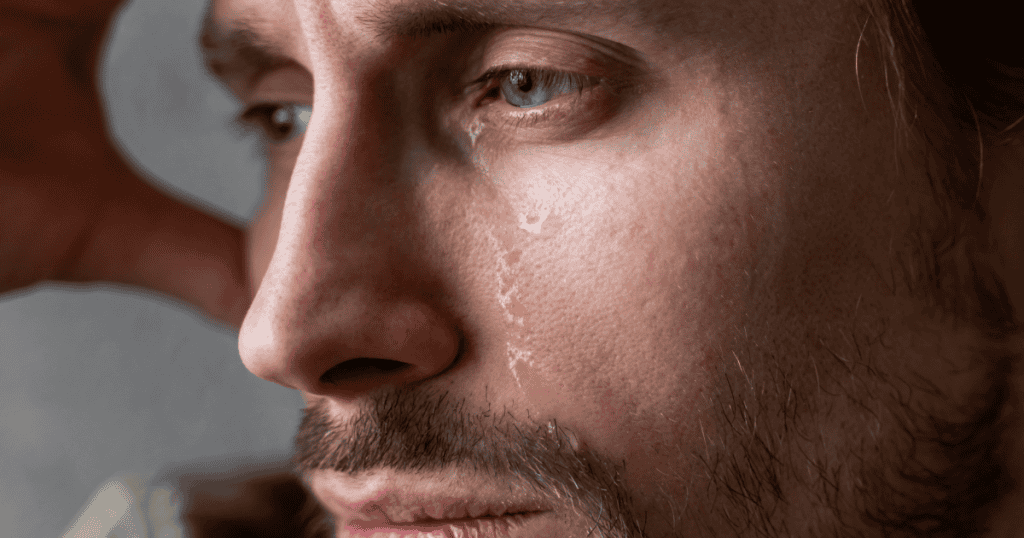 A close-up shot focuses on a man’s eye as a single tear falls, hinting at the various internal triggers that prompt such a display.