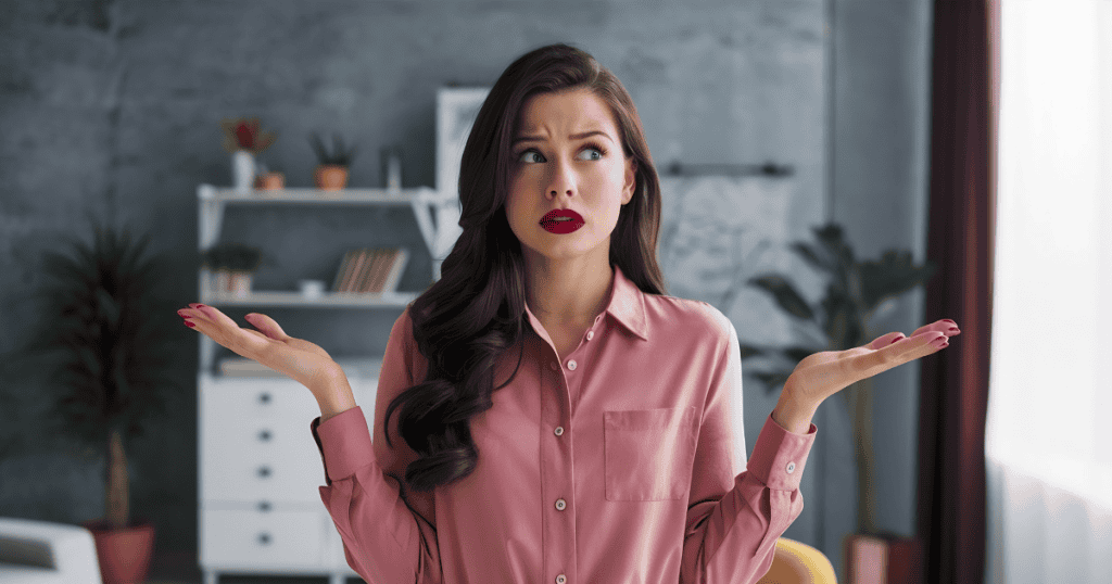 A woman stands with her palms upturned and a puzzled expression, capturing the disorientation that follows a manipulative emotional encounter.