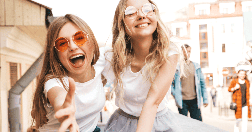 Two smiling friends share a carefree moment together, reflecting the nostalgic memories narcissists often use to draw you back into a toxic cycle.