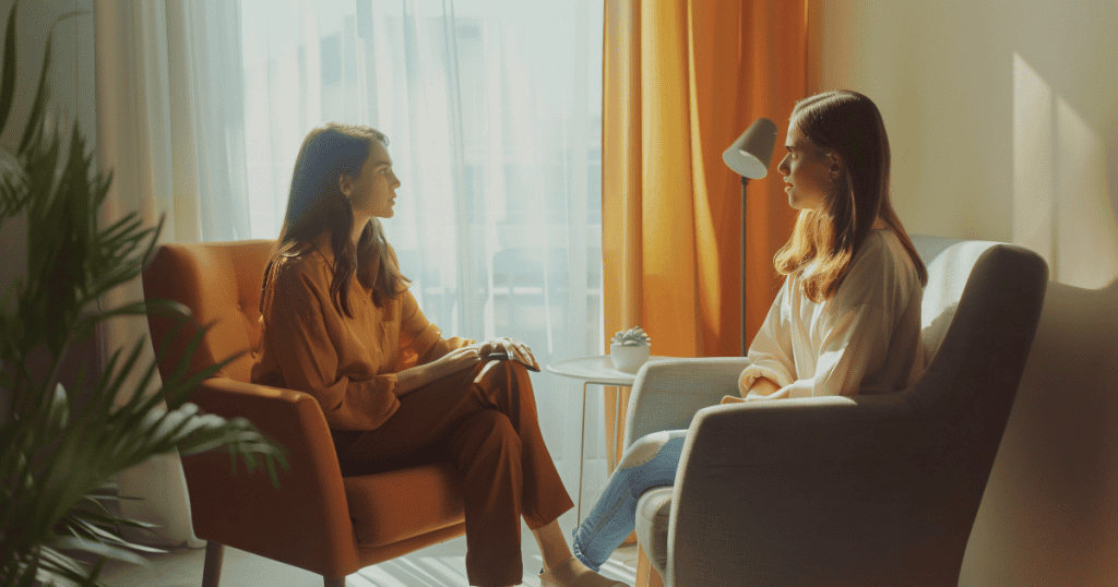 Two women from different generations stand face-to-face in a tense encounter, where the weight of unspoken, manipulative history hangs too heavy for standard dialogue.