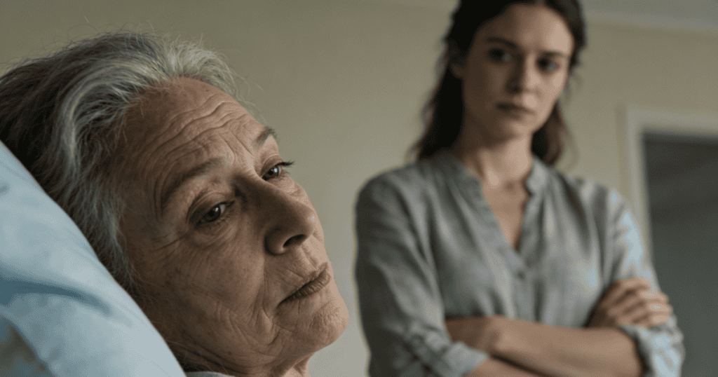 An older woman with gray hair looks off despondently from a hospital bed while a younger woman stands with crossed arms in the blurred background, capturing a stark, unchanged reality that stands in sharp contrast to past hopes.