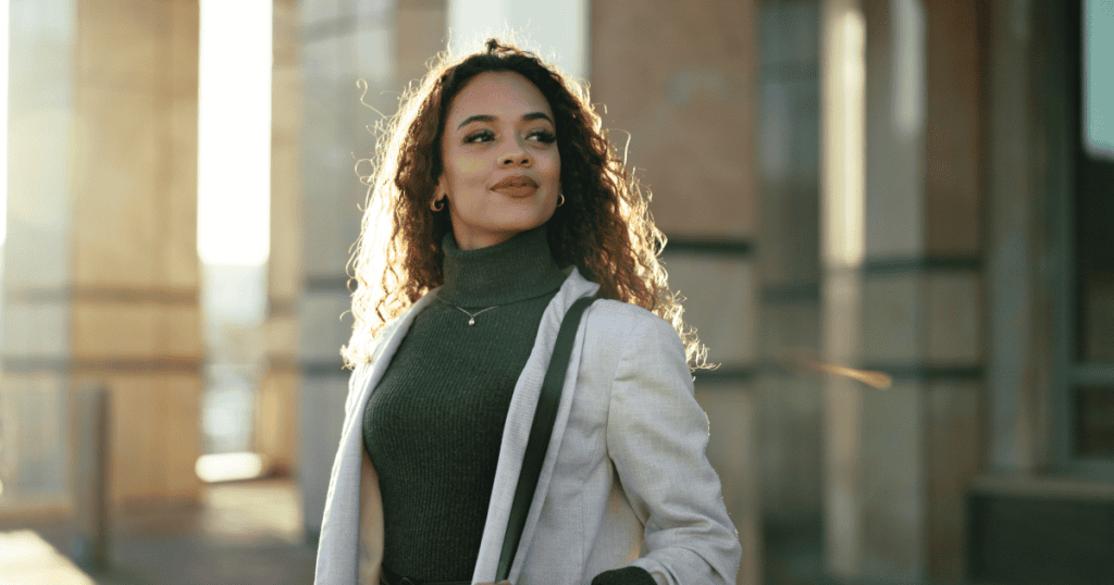 A confident woman standing tall outside a city building, embodying the quiet, unshakeable self-assurance that signals to a narcissist she is no longer available to be manipulated.
