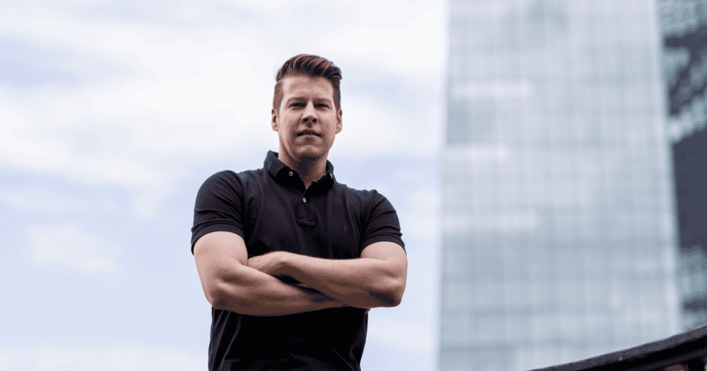 A man standing with arms crossed and a cold, intimidating stare, capturing a narcissist's last-ditch effort to reclaim dominance before losing control for good.