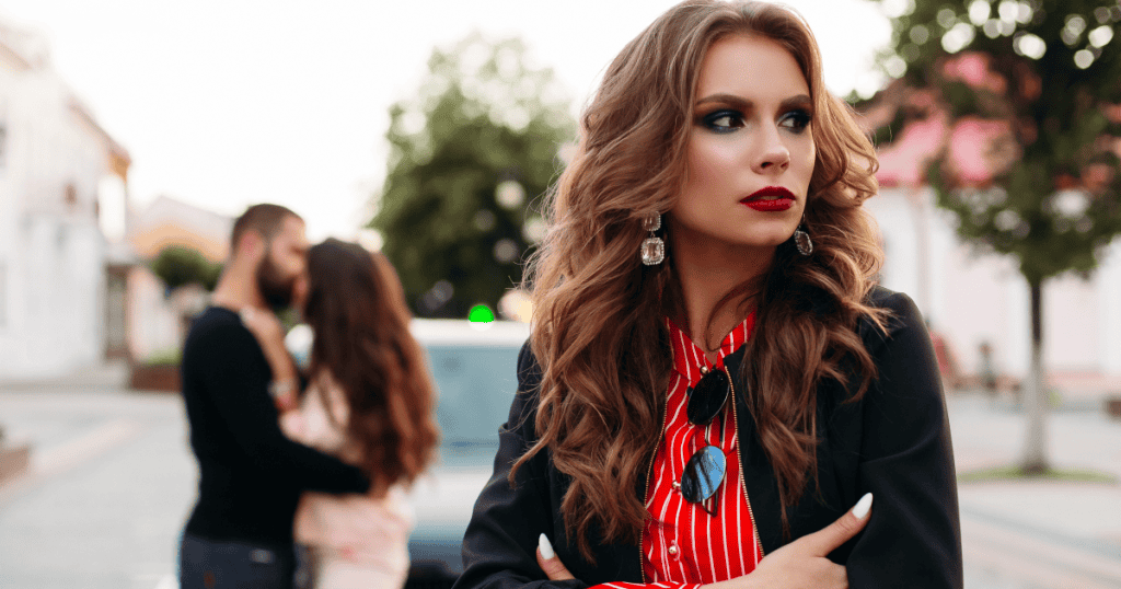 A woman watching a couple embrace behind her with a knowing, guarded look, capturing the painful illusion of a narcissist who appears transformed with their new partner while the cycle quietly repeats.