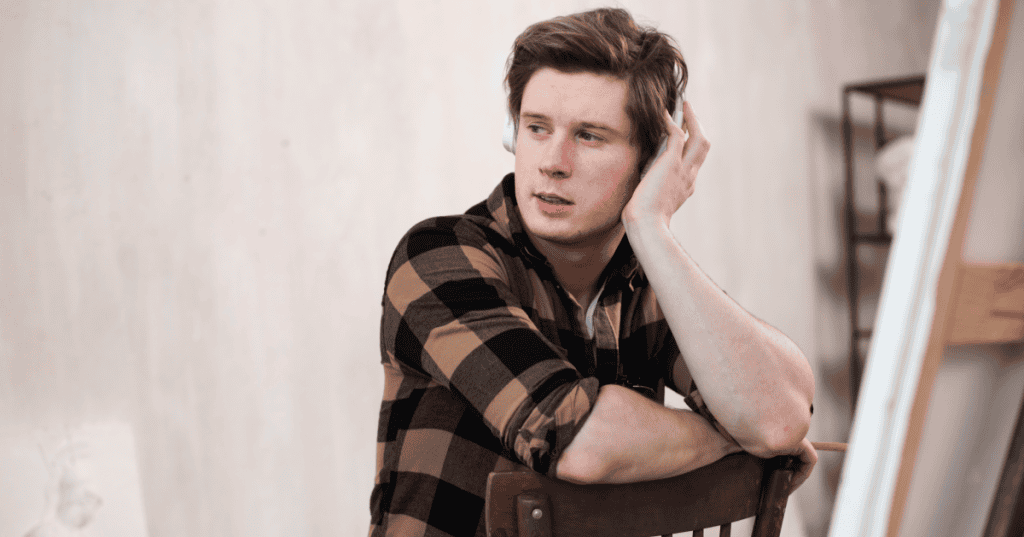 A young man sitting with headphones and a distant, unbothered expression, challenging the hopeful myth that a narcissist can simply choose to listen, reflect, and unlearn deeply ingrained patterns that science shows go far beyond behavior.