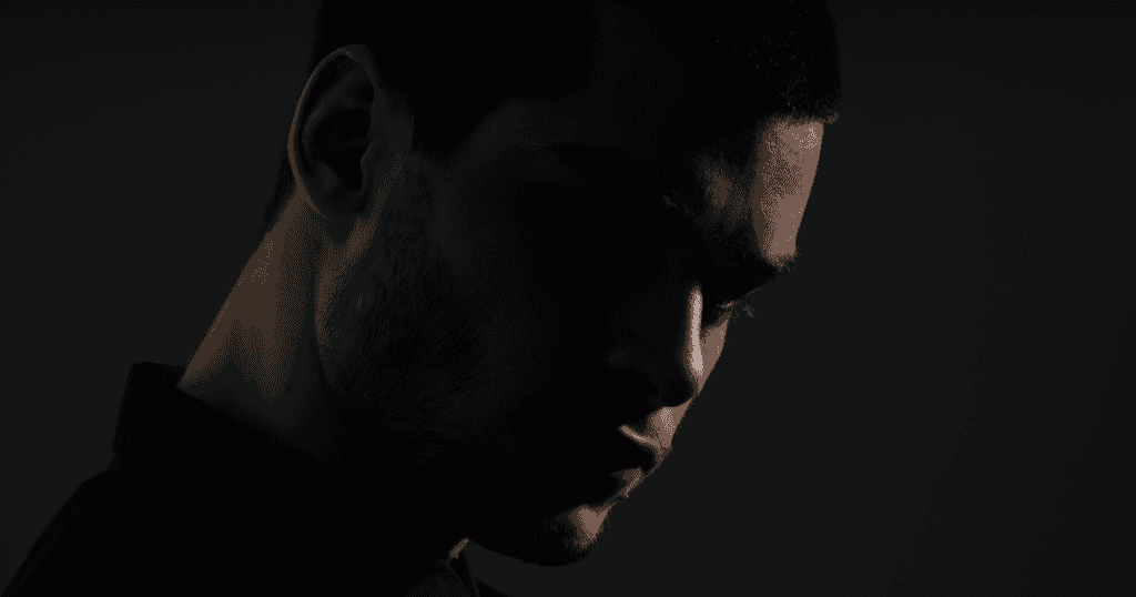 A man shrouded in dramatic shadow creating an air of dark mystery, debunking the myth that narcissists possess some otherworldly power, when in reality, science reveals they are driven by fear and insecurity, not supernatural mastery.