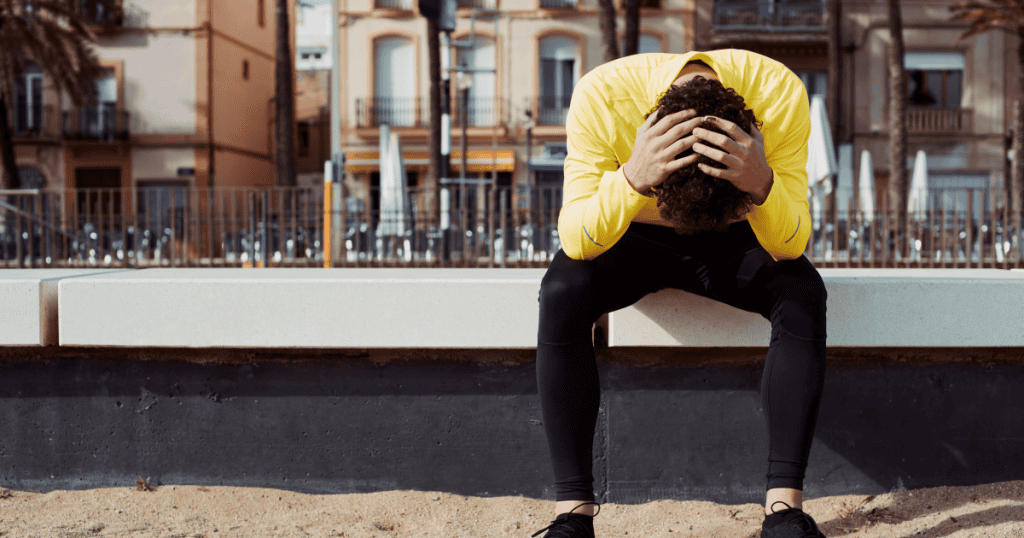 A man sitting alone with his head buried in his hands, depicting the breaking point a narcissist reaches when humiliating defeat strips away their facade and unleashes their most dangerous self.
