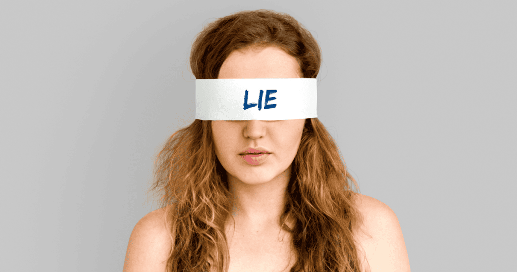 A woman with messy hair wears a white blindfold stamped with the word "LIE" in bold blue letters, capturing the disorienting darkness of being kept deliberately in the dark.