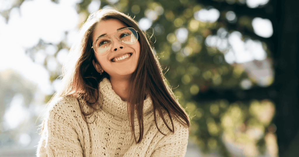 A woman smiling and gazing upward in the sunlight, embodying the peace that comes from finally releasing the guilt of feeling responsible for a narcissist's downfall.