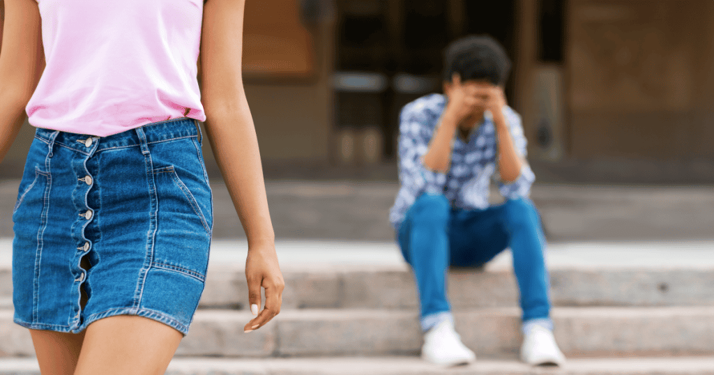 A woman walks away while a man sits on the steps behind her with his head in his hands, illustrating the emotional weight that makes leaving a narcissistic relationship far harder than it looks from the outside.