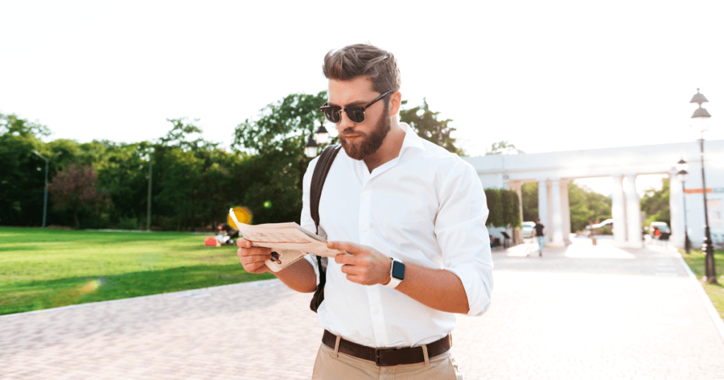 A man in sunglasses reads a document while walking through a sunny park, illustrating how a packed schedule always seems to make room for everything except the people closest to him.